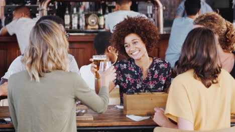 group of young friends meeting for drinks and food making a toast in restaurant