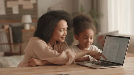 mother and daughter using a laptop together