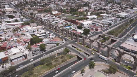 bustling traffic flow by arcos de querétaro, ancient aqueduct monument, mexico