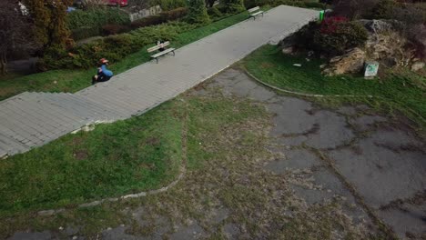 disparo aéreo de un dron siguiendo a un joven parkour masculino adulto corriendo libremente por el parque