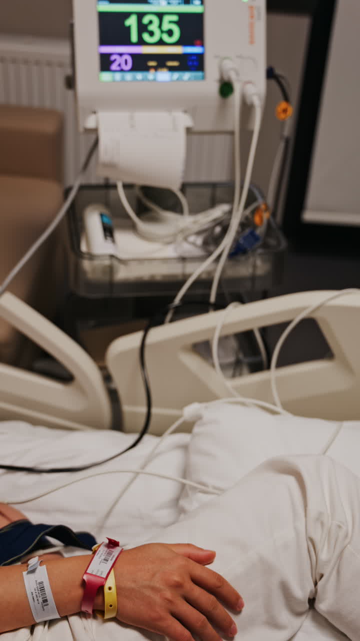 Pregnant woman lying in a hospital bed during a prenatal check-up at the doctor's office. Vertical