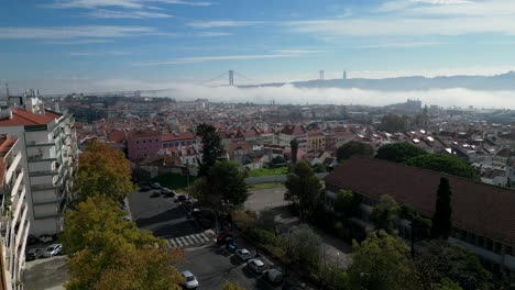 aerial view over lisbon city with the iconic 25 de abril bridge emerging majestically from a misty river, creating a captivating and atmospheric scene