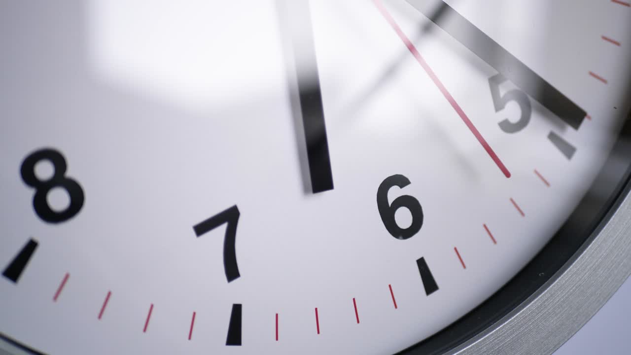 Close up of a ticking clock on white background, window reflection