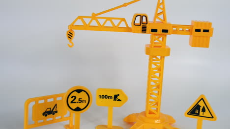 Construction-site-illustration,-yellow-truck,-sign-and-equipment,-toy-miniature-model,-background-studio-cinematic-concept-of-creative-mini-figurine-of-workplace