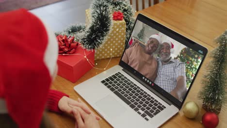 Glückliche-Kaukasische-Frau-Bei-Einem-Videoanruf-Mit-Einem-älteren-Paar-Zur-Weihnachtszeit