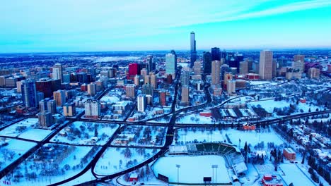 winter snow covered downtown east side edmonton alberta canada with hardly any traffic, nobody outside on a clear sunny afternoon overlooking the baseball diamond and highways connecting to roads