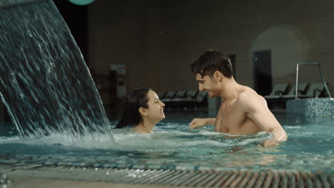 una pareja sensual abrazándose en la piscina del spa. un hombre y una mujer hermosos disfrutando de las vacaciones.