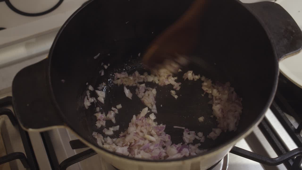 Mixing diced fried onion inside a hot cooking pot during cooking