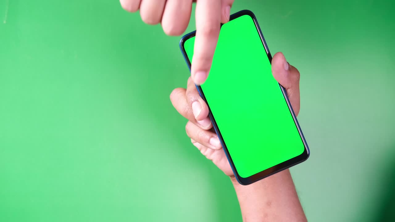 초록색 화면의 스마트폰을 들고 있는 사람