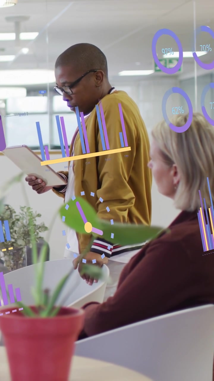Vertical video: Presenter reading tablet, presenting data charts and rings overlaying colleague