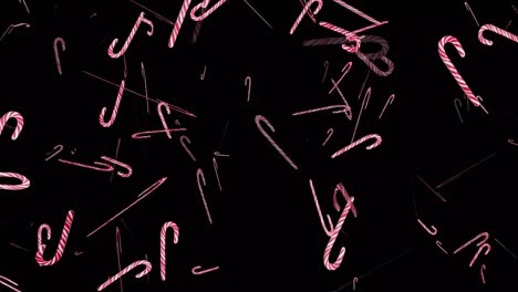 flying lollipops on a black background for composition. red candy canes