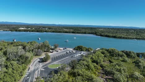 Aerial-drone-shot-orbiting-Beachmere-Boat-Ramps-on-Caboolture-River,-Boats-in-river-opening-to-the-Ocean-Moreton-Bay