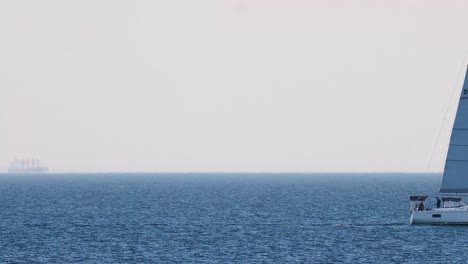 a sailboat moves across the ocean horizon