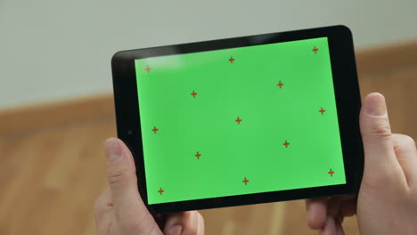 Männliche-Hände-Halten-Tablet.-Nahaufnahme-Eines-Mannes,-Der-Auf-Ein-Tablet-Mit-Grünem-Bildschirm-Tippt