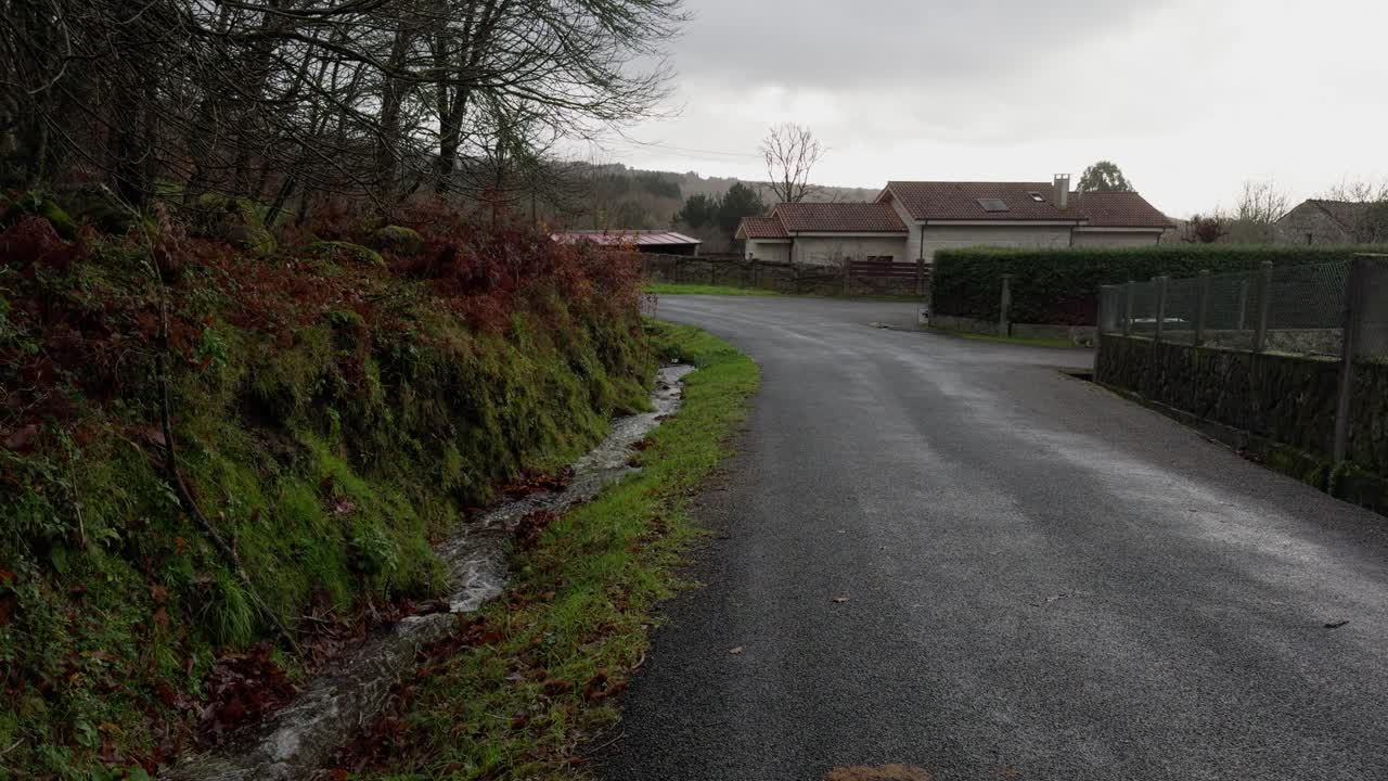 Small Stream Flowing Through A Natural Path Next To A Countryside Road