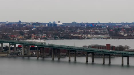 An-aerial-view-of-the-Throgs-Neck-Bridge-elevated-roadway-from-over-the-Long-Island-Sound,-NY-on-a-cloudy-day