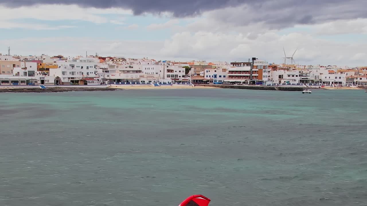 Windsurfisti cavalcano le onde nelle Isole Canarie, Spagna, in una giornata di sole