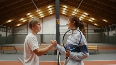 tennis players shaking hands on indoor court