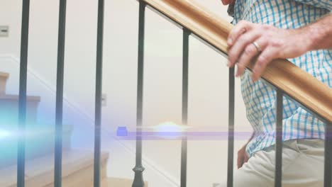 animation of light moving over midsection of senior caucasian man with cane climbing staircase