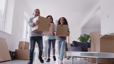 smiling family carrying boxes into new home on moving day