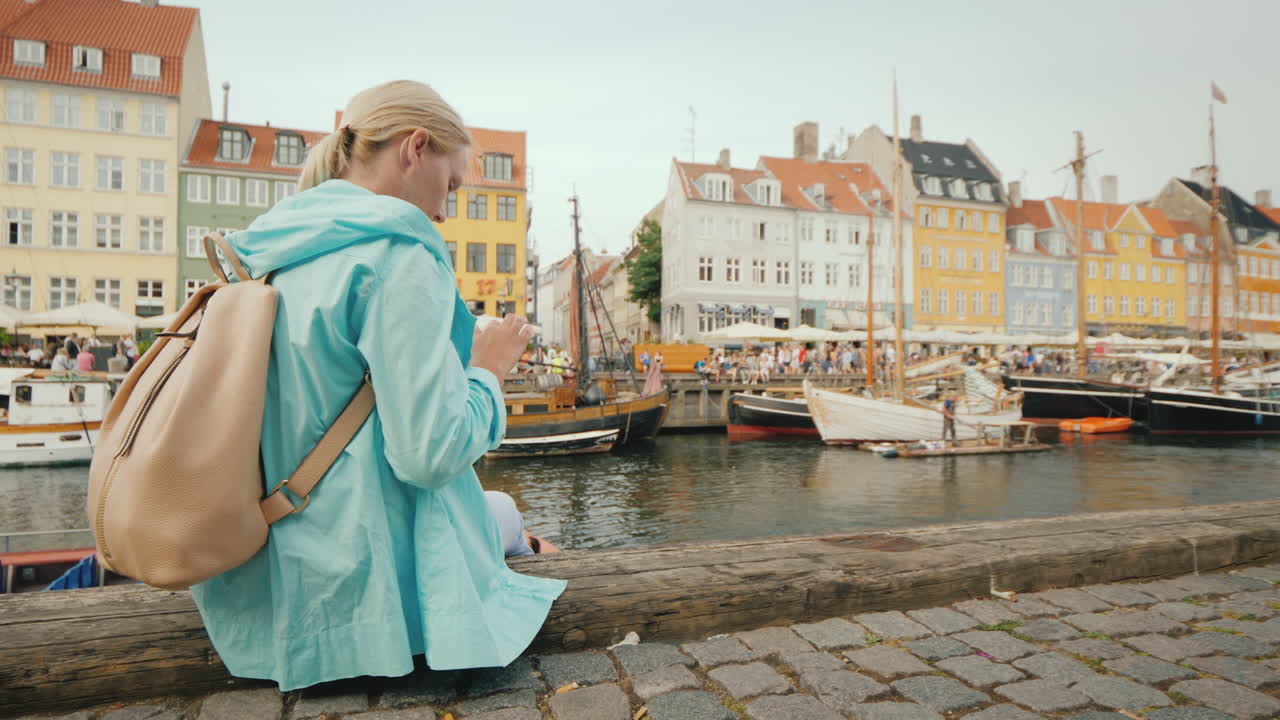 una mujer pasea por el canal con el telón de fondo de las famosas casas coloridas, la pl más popular