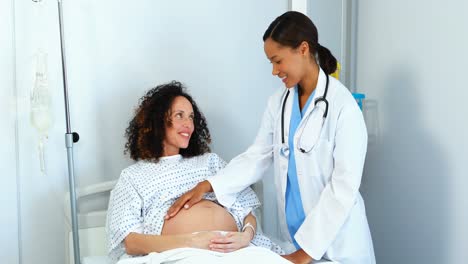 doctor examining pregnant woman in ward