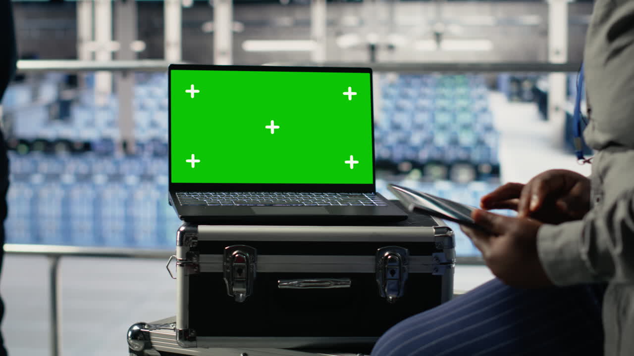 Colleghi IT monitorano l'attività della server farm usando un laptop con schermo isolato