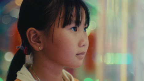 portrait of young child kid asiatic looking at the monitor screen of video games in amusement park