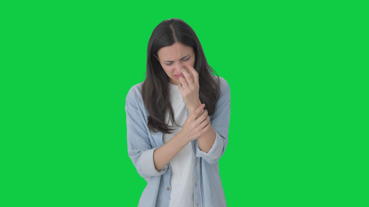 chica india enferma que sufre de dolor en la mano pantalla verde