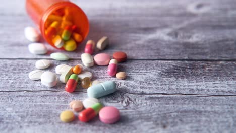 assorted pills and capsules on a wooden table