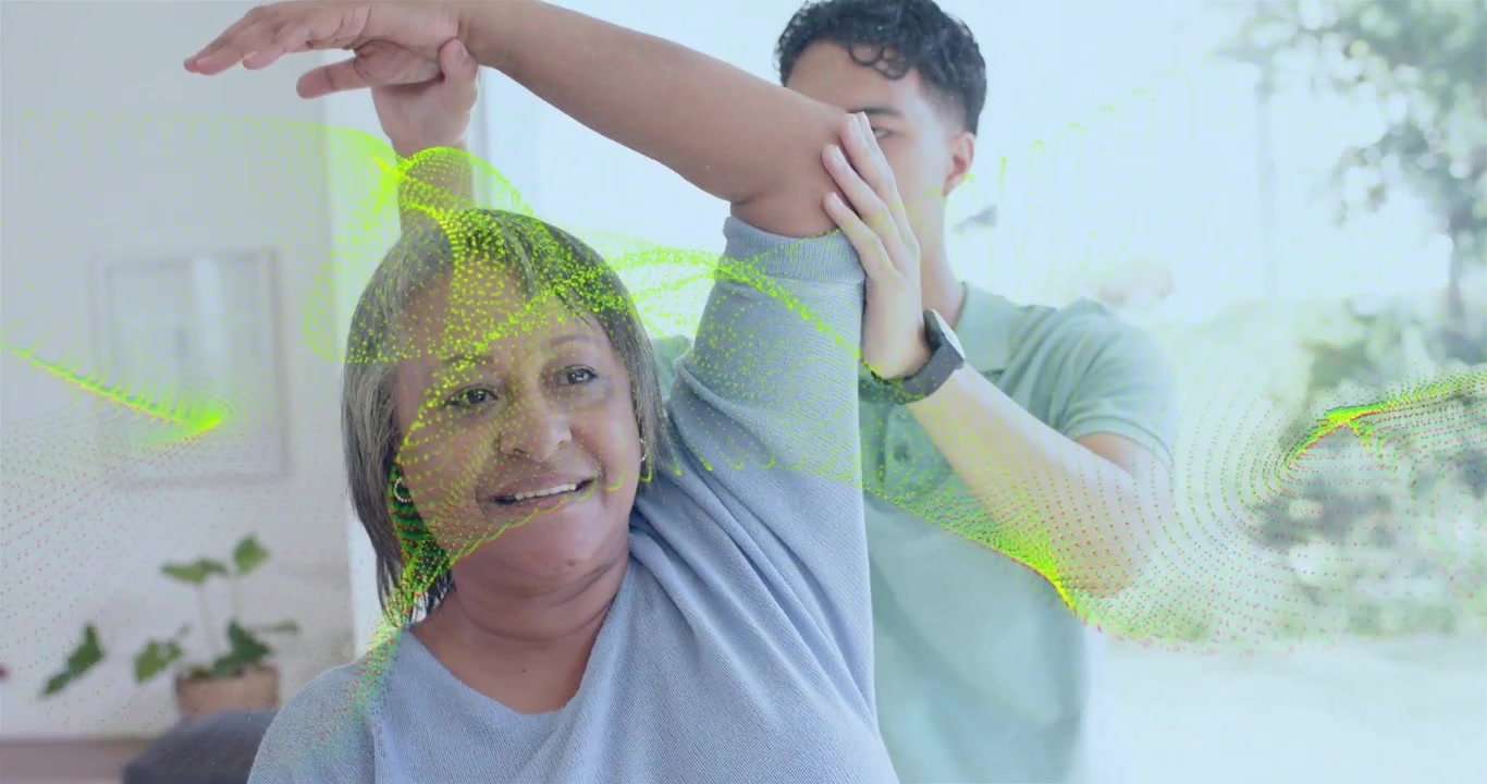 Cuidador colocando la mano para guiar a una persona mayor que levanta el brazo para terapia, reloj, malla verde mostrando el rango de movimiento del hombro.