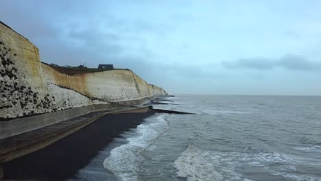 drone shot groynes and sea wall on coast of beach for erosion defense