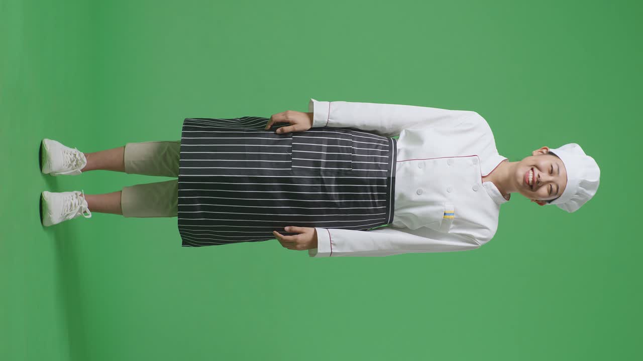 Full Body Of Asian Woman Chef Standing And Smiling To Camera In The Green Screen Background Studio