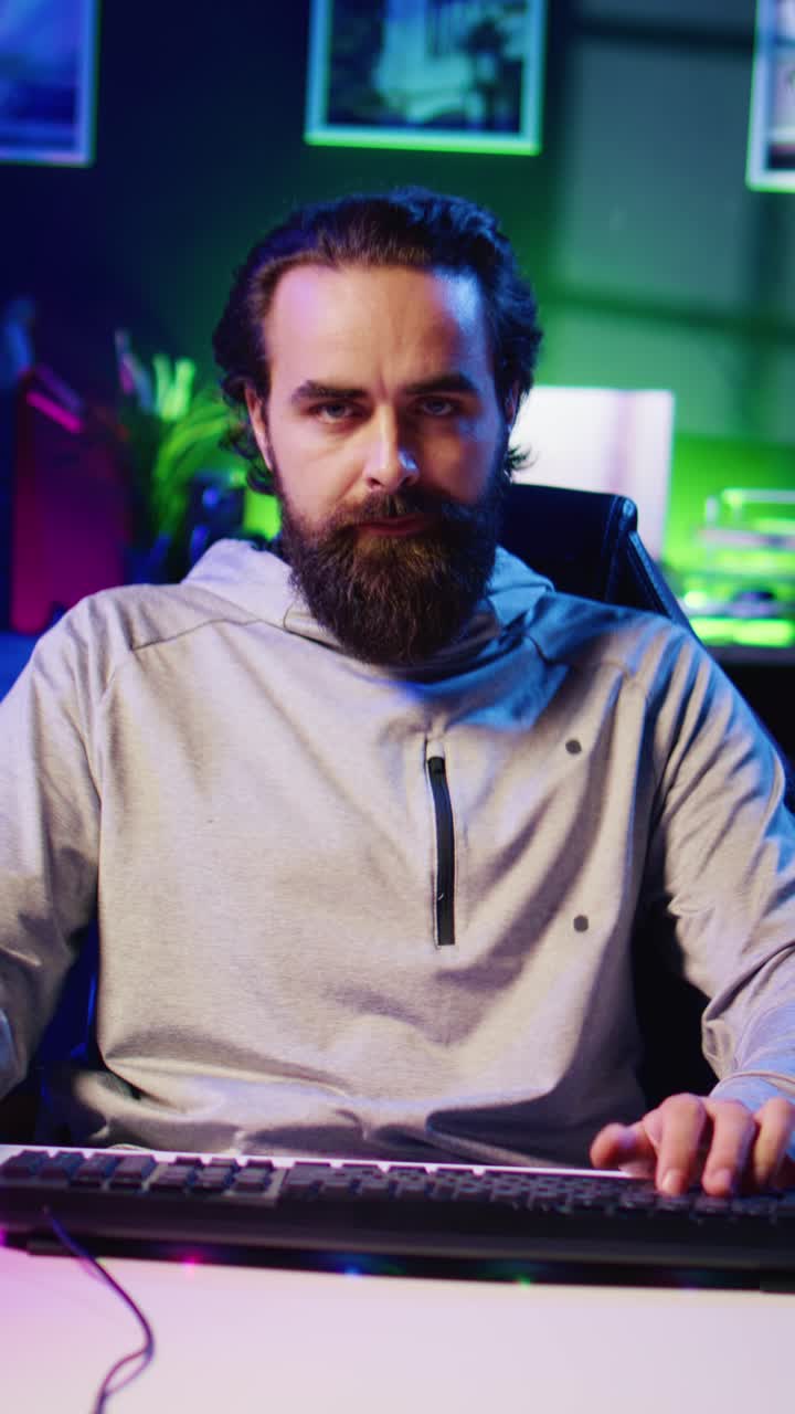 Video verticale: un uomo seduto su una sedia da gaming parla al pubblico e filma un tutorial su come sconfiggere i nemici