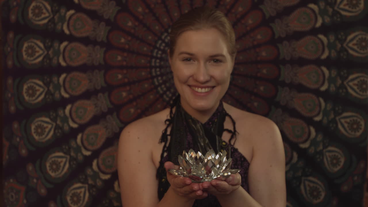 The magic of the ritual. Young woman holding a candle in a wellness salon. Mystery in pray. Magical moment in ayurvedic spa salon