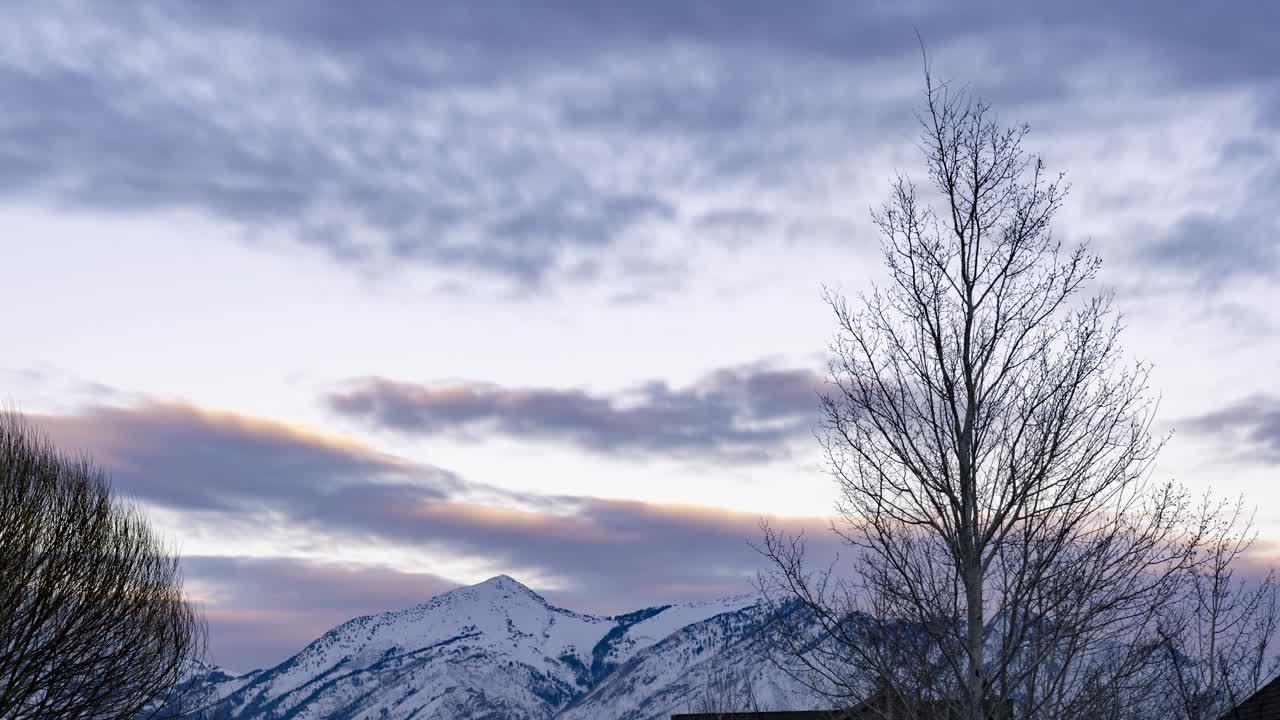 석양의 먼 눈 덮인 산 - 시간 경과를 축소하여 더 넓은 장면을 보여줍니다.