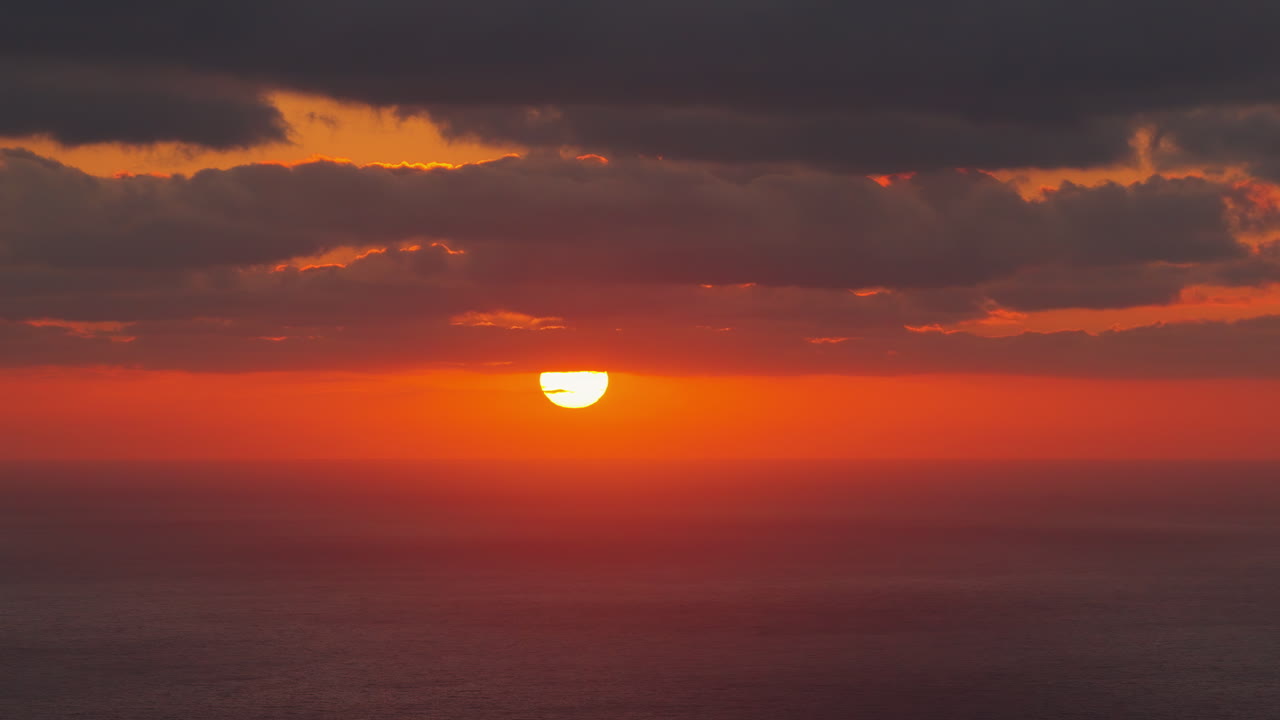 Luftfoto fra drone af gylden solnedgang, der reflekteres i det rolige Middelhav.