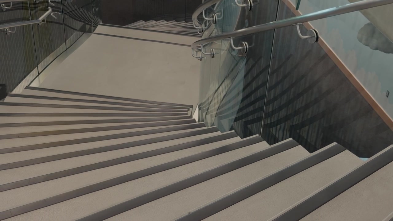Angled right to left glide along modern stairs ending behind a railing.