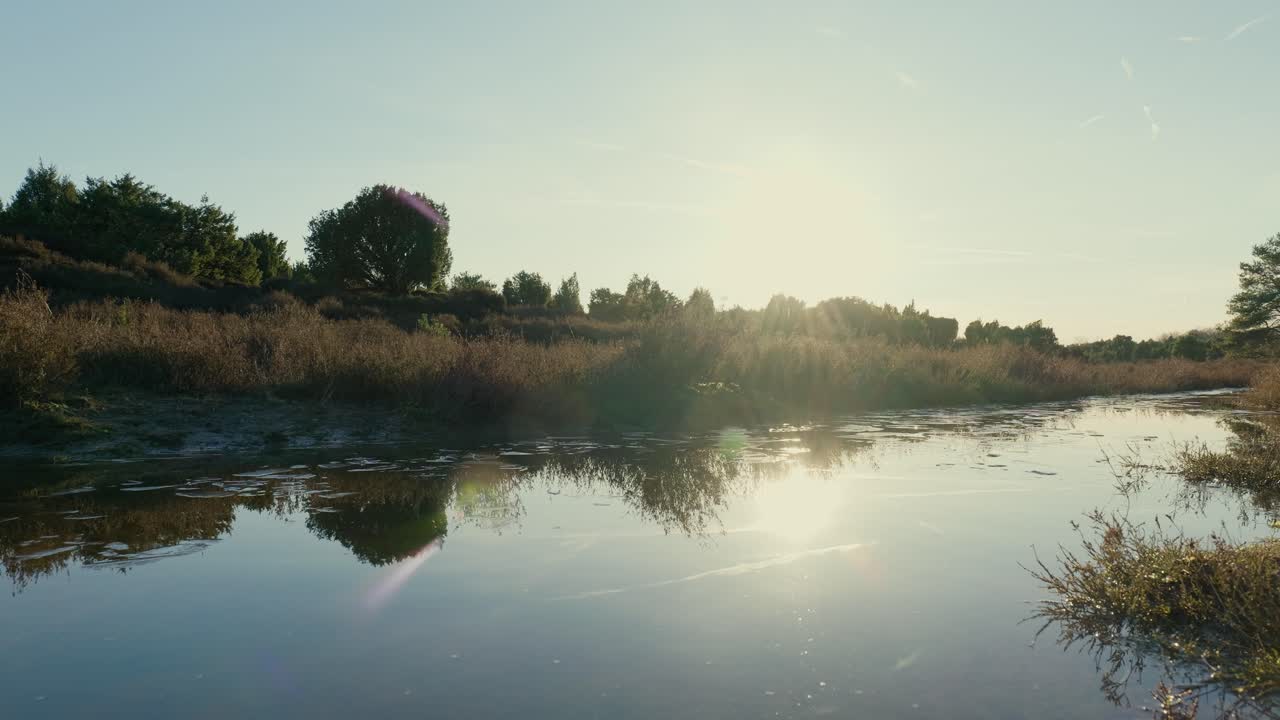 Sunset over a tranquil river in a woodland setting