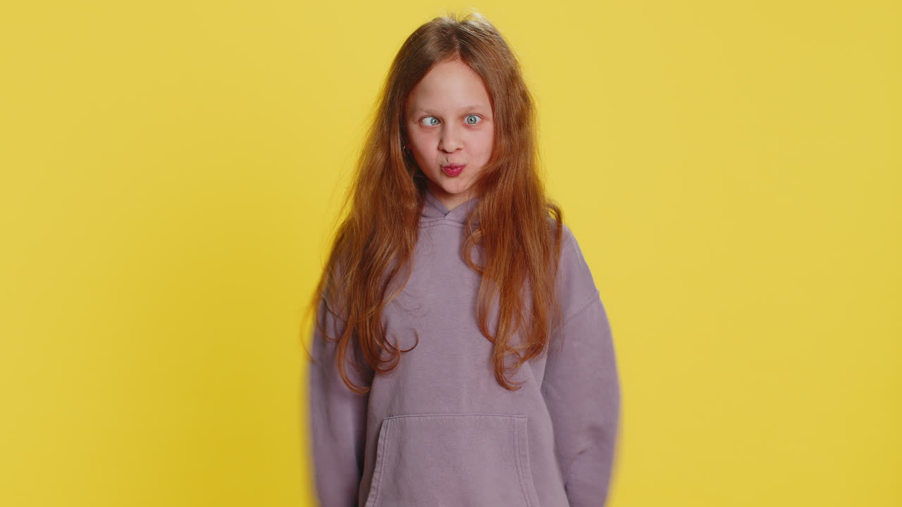 Cheerful funny bully child girl showing tongue making silly faces fooling around joking teasing