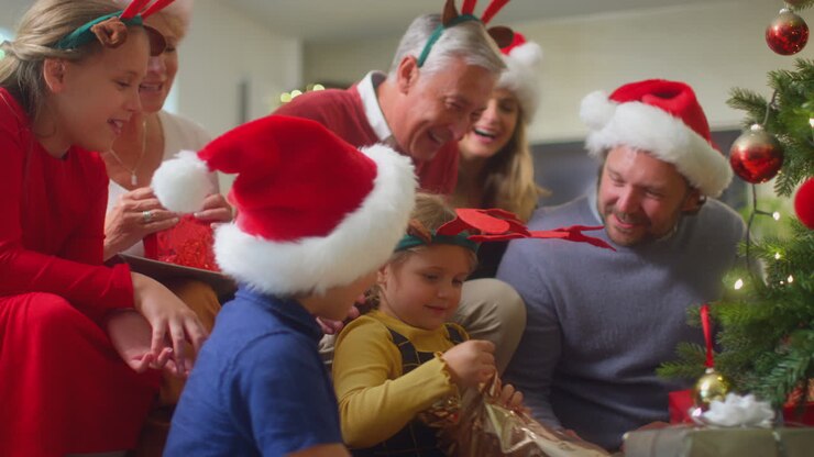 Multi-Generation Family Exchanging And Opening Gifts Around Christmas Tree At Home