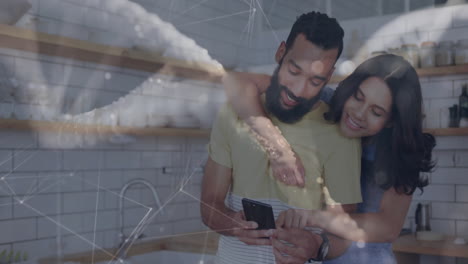 couple hugging while using smartphone in modern kitchen, showcasing smart home network graphics