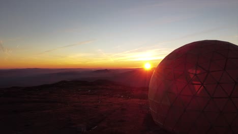sunset over mountains with radar dome