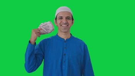 Happy-Muslim-man-using-money-as-fan-Green-screen