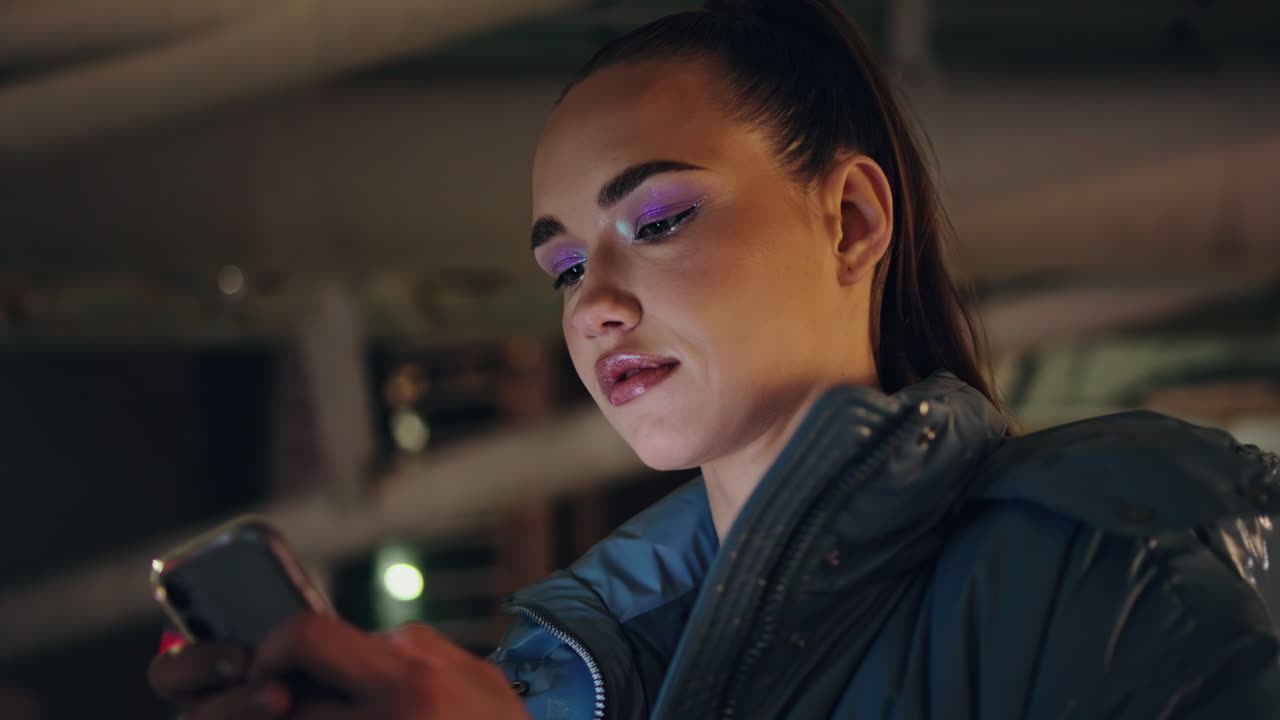 chica seria escribiendo sms en el teléfono inteligente noche al aire libre de cerca. womant por la noche