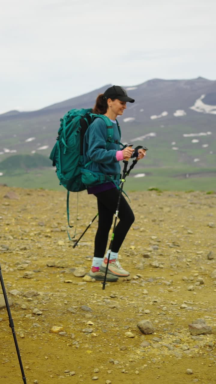 Due donne in escursione con zaini e bastoncini da trekking su un sentiero di montagna roccioso