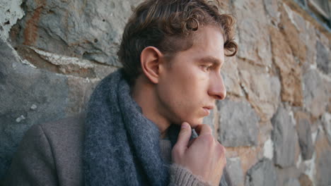 thoughtful poet thinking ideas at ancient castle wall closeup. guy pondering