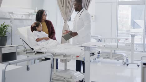worried diverse mother with her sick daughter patient talking to doctor in hospital in slow motion