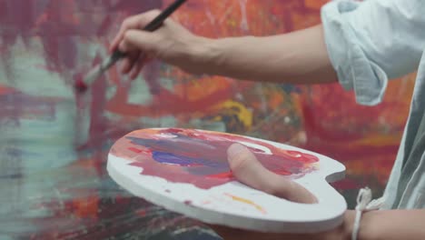 hand holding paint brush and painting art