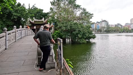 people fishing and walking on a bridge